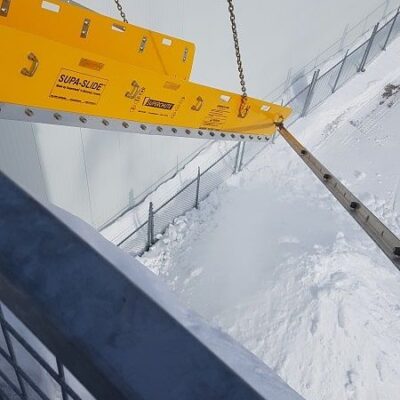 Superchute Snow Slide being used to clear snow from a building roof.